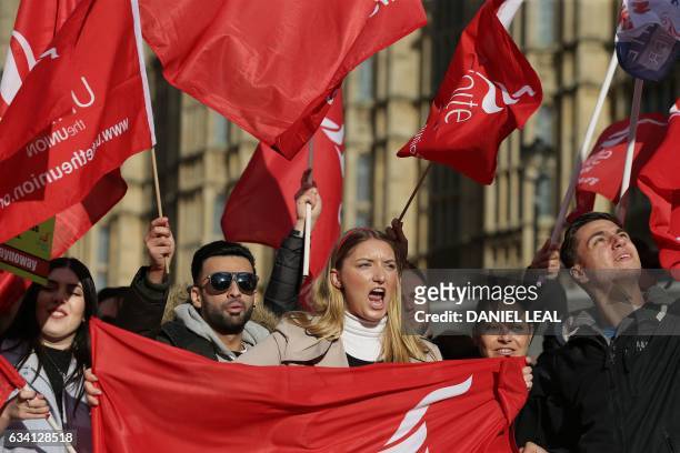 Demonstrators hold placards and wave flags as they protest against the low wages and "poverty pay" of British Airways' staff, outside the Houses of...