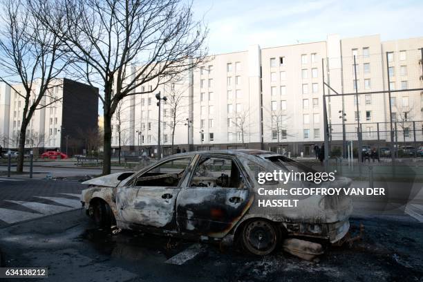 Picture taken on February 7, 2017 shows the wreckage of a burnt car in one of the main streets of the Rose des Vents district also known as the Cite...