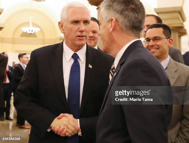 Vice President Mike Pence shakes hands after the Senate voted to confirm Betsy DeVos as education secretary on Capitol Hill on February 7, 2017 in...
