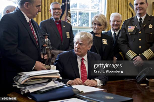 President Donald Trump receives a statue while meeting with county sheriffs in the Oval Office of the White House in Washington, D.C., U.S., on...