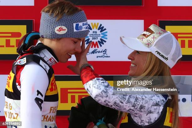 Gold medallist Nicole Schmidhofer of Austria is consoled by bronze medallist Lara Gut of Switzerland during the flower ceremony for the Women's Super...