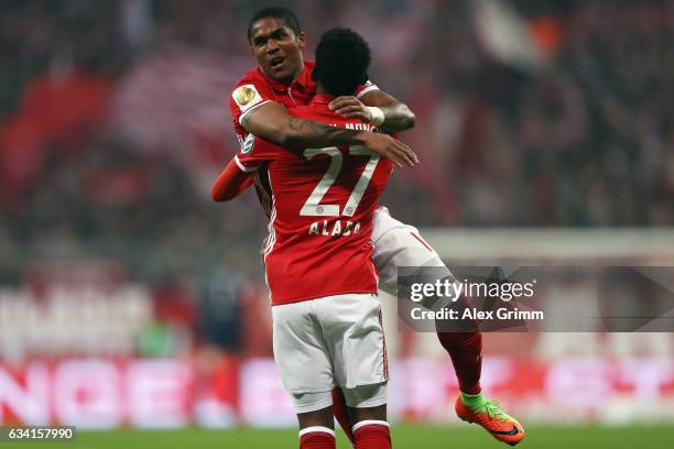 Douglas Costa of Muenchen celebrates his team's first goal with team mate David Alaba during the DFB Cup Round Of 16 match between Bayern Muenchen...