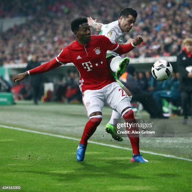 David Alaba of Muenchen is challenged by Vieirinha of Wolfsburg during the DFB Cup Round Of 16 match between Bayern Muenchen and VfL Wolfsburg at...