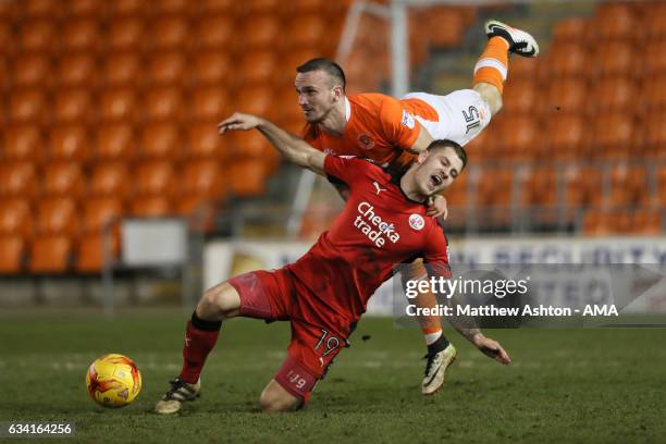 Tom Aldred of Blackpool heads the ball away from James Collins of Crawley Town during the Sky Bet League Two match between Blackpool and Crawley Town...