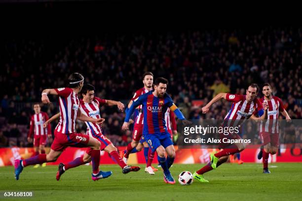 Lionel Messi of FC Barcelona runs with the ball between Filipe Luis , Nicolas Gaitan and Diego Godin of Atletico de Madrid during the Copa del Rey...