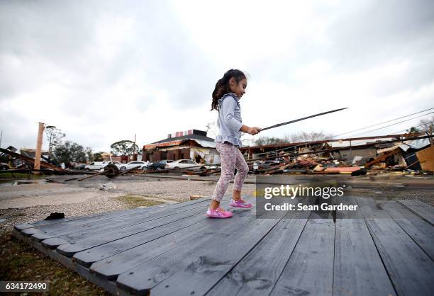 Little girl plays with a broken stick amongst the debris that was left behind by a tornad on on February 7, 2017 in New Orleans, Louisiana. According...