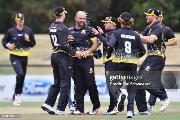 Luke Woodcock of Wellington is congratulated by team mates after dismissing Tom Latham of Canterbury during the Ford Trophy match between Canterbury...