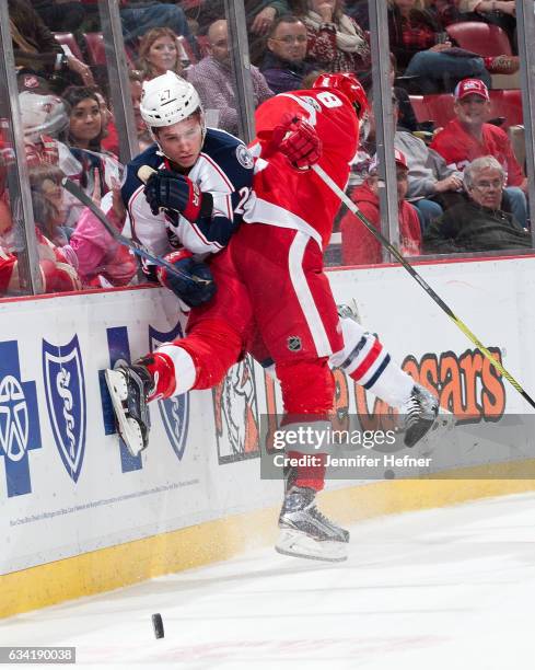 Justin Abdelkader of the Detroit Red Wings checks Ryan Murray of the Columbus Blue Jackets into the boards during an NHL game at Joe Louis Arena on...