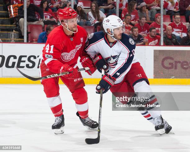 Luke Glendening of the Detroit Red Wings and Brandon Saad of the Columbus Blue Jackets battle for position during an NHL game at Joe Louis Arena on...