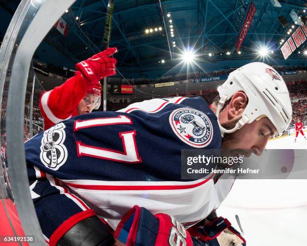 Brandon Dubinsky of the Columbus Blue Jackets and Nick Jensen of the Detroit Red Wings battle for the puck along the boards during an NHL game at Joe...