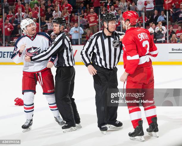 Linesmen Devin Berg and Scott Driscoll break up a fight between Scott Hartnell of the Columbus Blue Jackets and Brendan Smith of the Detroit Red...