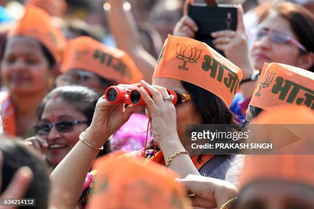 Supporter of Indian Prime Minister and Bharatiya Janata Party Leader Narendra Modi uses binoculars to view the scene at a state assembly election...