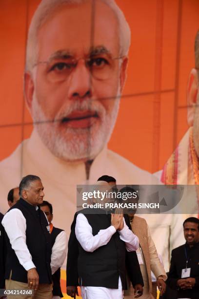 Indian Prime Minister and Bharatiya Janata Party Leader Narendra Modi gestures as he walks alongside former army General V.K. Singh at a state...