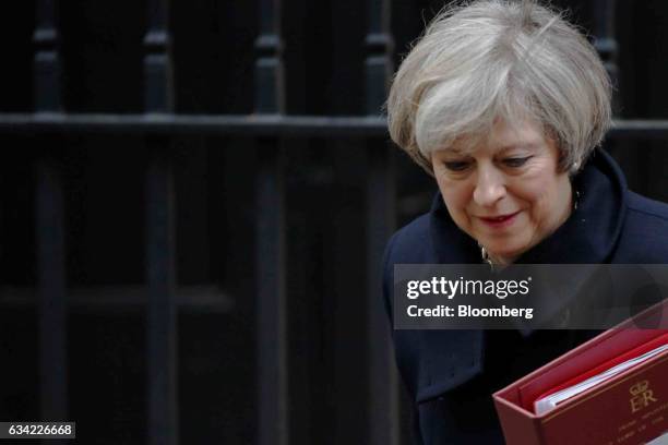 Theresa May, U.K. Prime minister, carries a document folder as she leaves 10 Downing Street to attend the weekly question-and-answer session in...