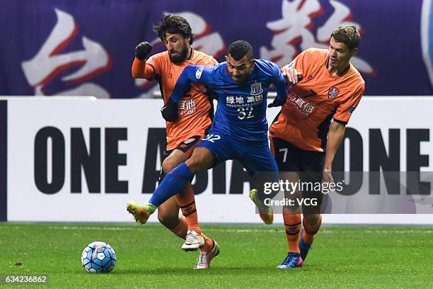 Carlos Tevez of Shanghai Shenhua and Thomas Broich, Thomas Kristensen of Brisbane Roar compete for the ball during the AFC Champions League 2017...