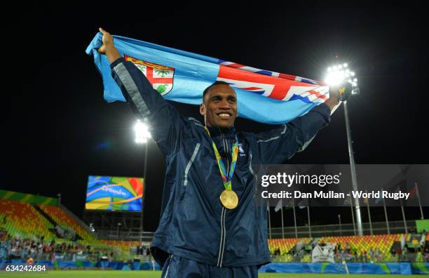 Osea Kolinisau of Fiji poses with the Fiji flag following victory during the Men's Rugby Sevens Gold Medal match between Fiji and Great Britain on...