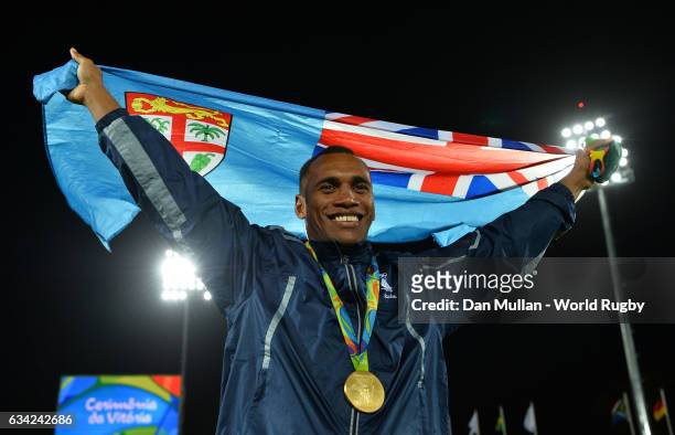 Osea Kolinisau of Fiji poses with the Fiji flag following victory during the Men's Rugby Sevens Gold Medal match between Fiji and Great Britain on...