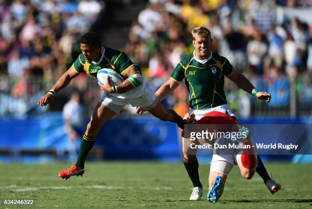 Juan de Jongh of South Africa is tackled by Phil Burgess of Great Britain during the Men's Rugby Sevens semi final match between Great Britain and...
