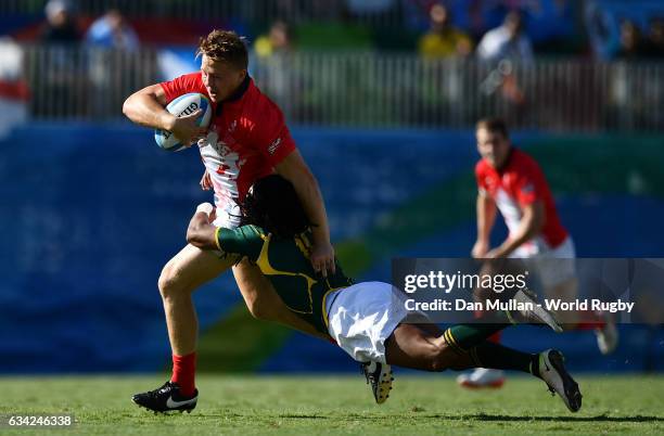 James Davies of Great Britain is tackled by Cecil Afrika of South Africa during the Men's Rugby Sevens semi final match between Great Britain and...