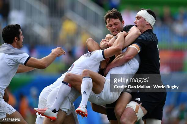 Terry Bouhraoua of France is tackled by Teddy Stanaway of New Zeland and Sam Dickson of New Zeland during the Men's Rugby Sevens placing match...