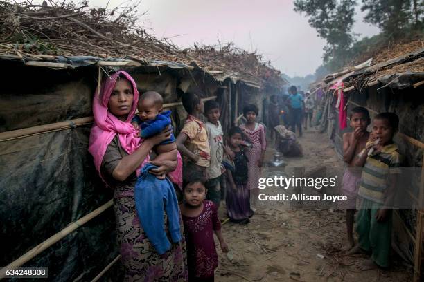 People stand outside their shelters in Kutapalong Rohingya refugee camp on February 8, 2017 in Cox's Bazar, Bangladesh. The United Nations estimates...