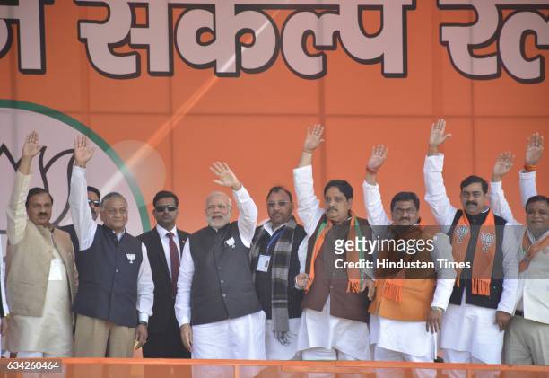 Prime Minister Narendra Modi along with Union Ministers Mahesh Sharma, VK Singh and other BJP leaders waves hand to greet the supporters during a BJP...