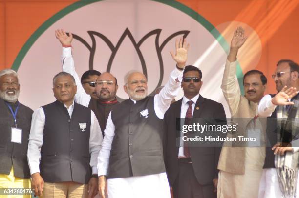 Prime Minister Narendra Modi along with Union Ministers Mahesh Sharma, VK Singh and other BJP leaders waves hand to greet the supporters during a BJP...