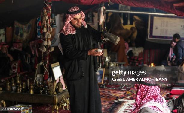 Syrian Bedouins pours coffee in a camp during a gathering of tribesmen near the town of Hamouria, in the eastern Ghouta region on the outskirts of...