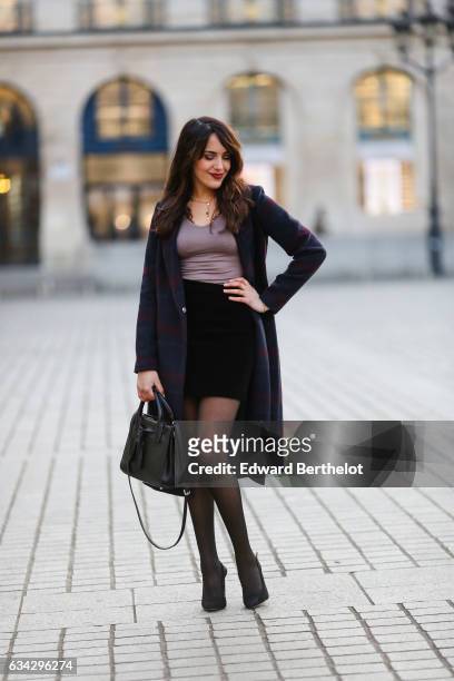 Sarah Benziane, fashion blogger from Les Colonnes de Sarah, wears a Dezzal black bag, Newlook black heels, black tights, a Newlook black skirt, a...