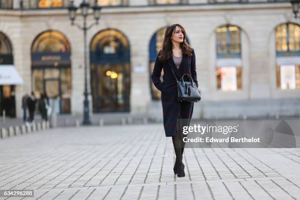 Sarah Benziane, fashion blogger from Les Colonnes de Sarah, wears a Dezzal black bag, Newlook black heels, black tights, a Newlook black skirt, a...