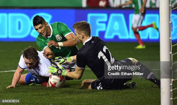 David Thor Vidarsson of Iceland tries to block a shot by Alan Pulido of Mexico as goaltender Frederik Schram of Iceland defends during their...