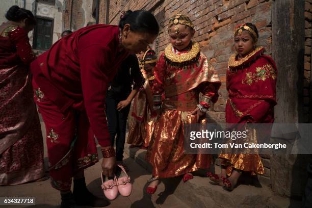 Young Nepalese girls dressed up as brides dry their red painted feet in the sun during the Bel Bibaha ritual, celebrated by the Newari ethnicity,...