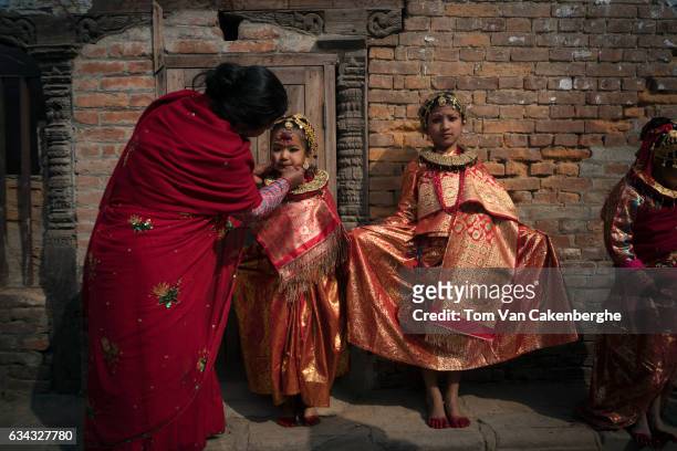 Young Nepalese girls dressed up as brides dry their red painted feet in the sun during the Bel Bibaha ritual, celebrated by the Newari ethnicity,...