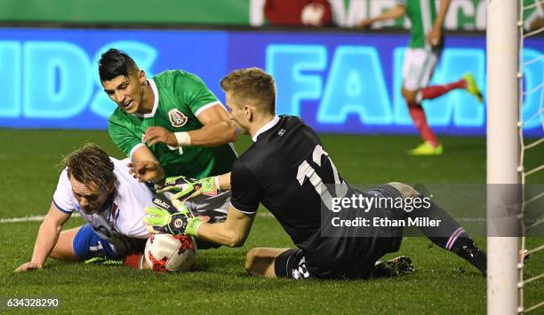 David Thor Vidarsson of Iceland tries to block a shot by Alan Pulido of Mexico as goaltender Frederik Schram of Iceland defends during their...