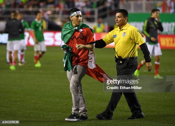 Security guard removes a fan who ran onto the field after Mexico defeated Iceland 1-0 in an exhibition match at Sam Boyd Stadium on February 8, 2017...