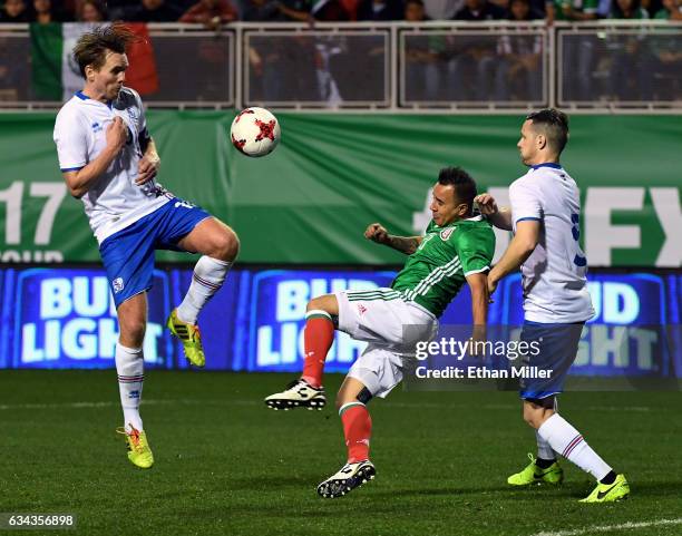 Luis Montes of Mexico kicks the ball up the field under pressure from David Thor Vidarsson and Hallgrimur Jonasson of Iceland during their exhibition...