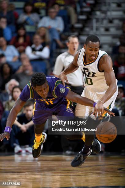 Jrue Holiday of the New Orleans Pelicans and Alec Burks of the Utah Jazz dive for a loose ball during the game on February 8, 2017 at the Smoothie...