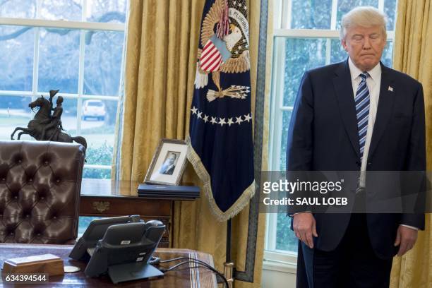 President Donald Trump stands behind his desk after Jeff Sessions was sworn in as Attorney General in the Oval Office of the White House in...