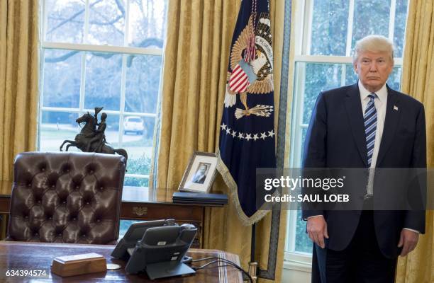 President Donald Trump stands behind his desk after Jeff Sessions was sworn in as Attorney General in the Oval Office of the White House in...