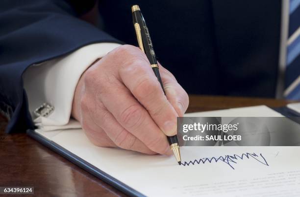 President Donald Trump signs an executive order related to crime after Jeff Sessions was sworn in as Attorney General in the Oval Office of the White...