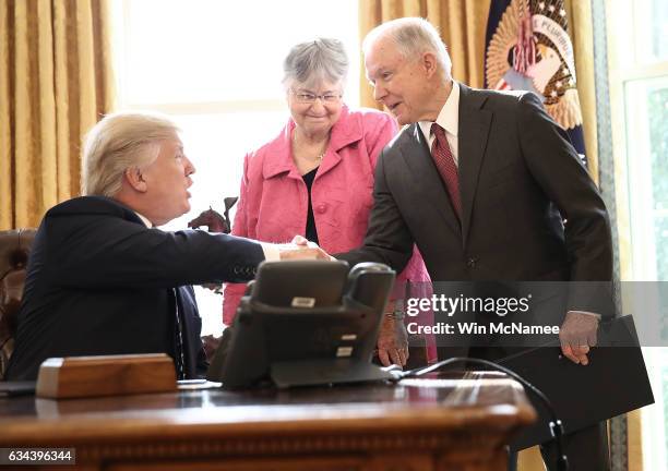 Attorney General Jeff Sessions shakes hands with U.S. President Donald Trump after Trump signed three executive orders following the swearing in...