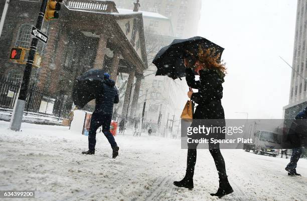 Pedestrians walk in the snow and wind in Manhattan on February 9, 2017 in New York City. A major winter storm warning is forecast from Pennsylvania...