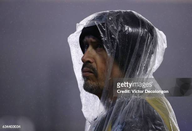 Hooded field security guard looks on as rain falls during the friendly match between Club Tijuana and the Los Angeles Galaxy at StubHub Center on...