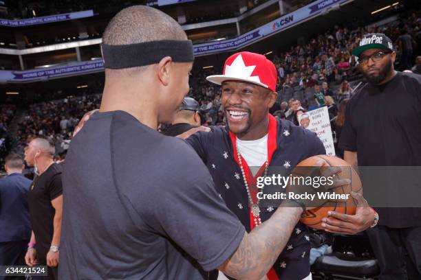 Boxer, Floyd Mayweather talks with Isaiah Thomas of the Boston Celtics before the game against the Sacramento Kings at Golden 1 Center on February 8,...