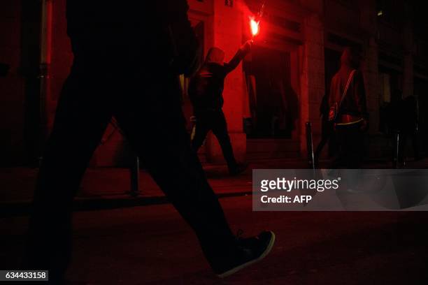Demonstrator holds a flare during a protest in support of a man allegedly abused while in police custody in Aulnay-sous-Bois, on February 9, 2017 in...