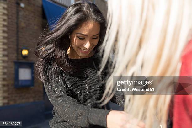 smiling young woman scrutinizing female friend - jury - entertainment photos et images de collection