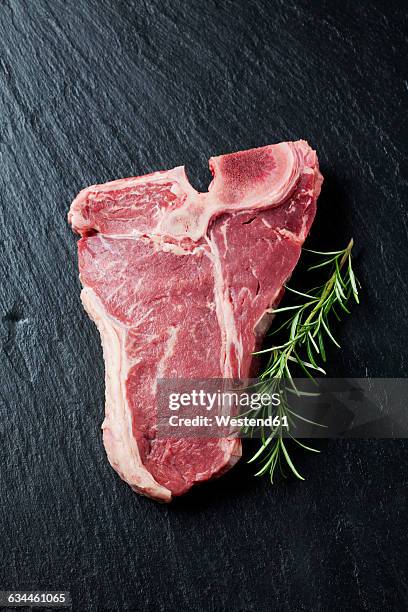 raw porterhouse steak with rosmary - schist stock-fotos und bilder