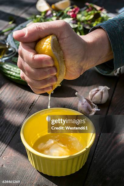 spring salad of baby spinach, herbs, arugula and lettuce, squeezing lemon, dressing of yogurt, olive oil, honey and lemon - salad tossing stock pictures, royalty-free photos & images