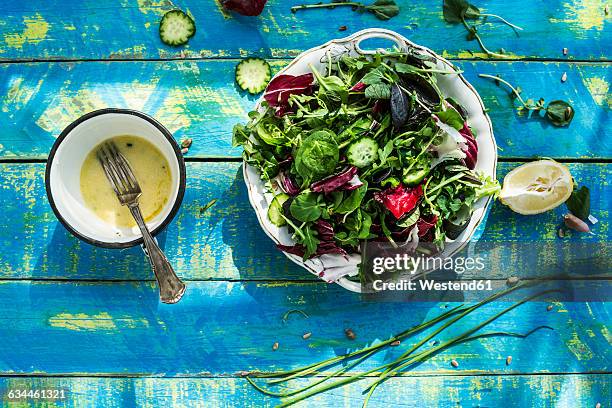 spring salad of baby spinach, herbs, arugula and lettuce, dressing of yogurt, olive oil, honey and lemon - dressing up stock-fotos und bilder