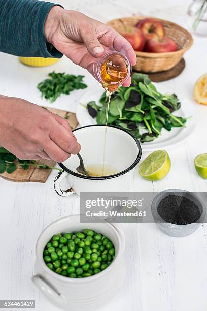 hand preparing a salad adding honey in the dressing - vinaigrette dressing photos et images de collection